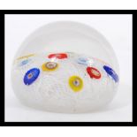 A 20th Century glass paperweight with random murrine canes atop a muslin ground cased in a clear