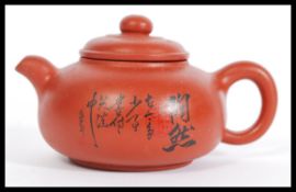 A 20th Century Yi Xing red clay tea pot having Chinese character marks to the side. Measures 7cm