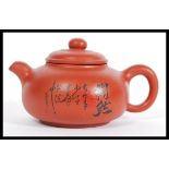 A 20th Century Yi Xing red clay tea pot having Chinese character marks to the side. Measures 7cm