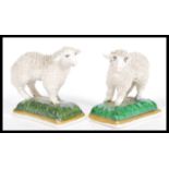 A pair of 19th Century Victorian Staffordshire miniature sheep / lamb figurines raised on plinth