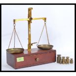 A set of vintage 20th Century brass spice / jewellery balance scales raised on a wooden base with