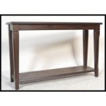 A 20th century contemporary oak console table of rectangular form having square tapering legs united