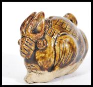 A Chinese stoneware whistle in the form of a large hare having partial glazed top and hole to top.