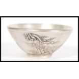 An early 20th Century Chinese silver plated prayer bowl of conical form having relief decoration