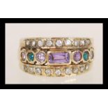 A 9ct gold ring set with a row of purple and green stones flanked by two rows of white stones.