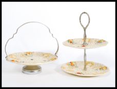 An early 20th century Clarice Cliff ' Celtic Harvest '  two tier cake stand, moulded fruit and wheat