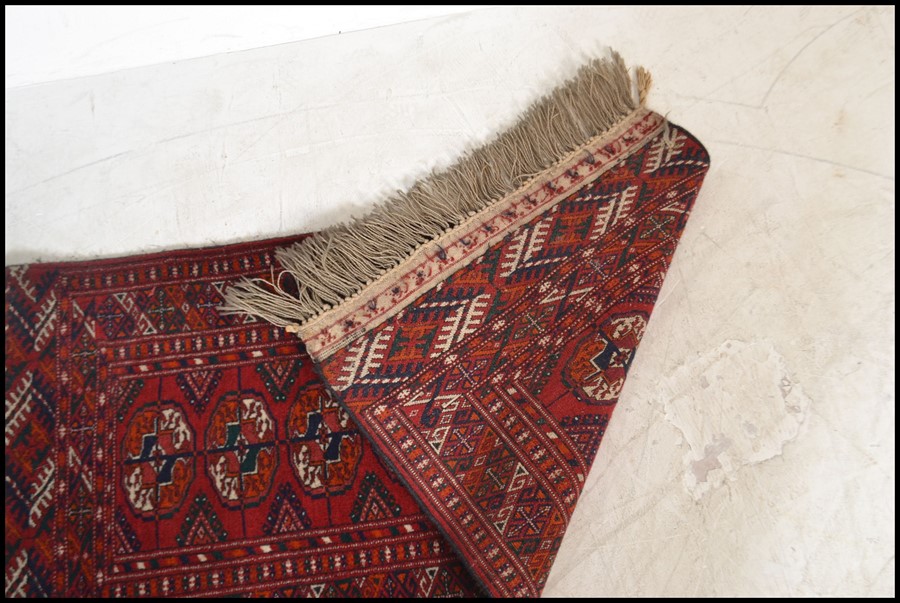 An early 20th century Islamic - Persian Bokhara rug with burnt orange ground having geometric - Image 4 of 4