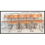 A set of eight vintage retro 20th Century ply stacking school chairs raised on tubular supports.