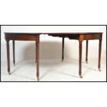A George III mahogany crossbanded and inlaid extending d-end dining table. Raised on turned legs