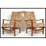 A pair of 1940's fireside armchairs in the manner of Heals of London. Each with mahogany frames