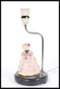 A Royal Doulton ceramic figurine lamp of a lady in Victorian dress and bonnet, raised on a