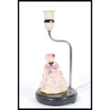 A Royal Doulton ceramic figurine lamp of a lady in Victorian dress and bonnet, raised on a