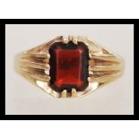 A hallmarked 9ct gold ring having a large faceted red stone with prong surrounds. Weighs 3.4 grams