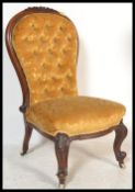 A Victorian 19th century mahogany spoon back nursing chair of rococo form raised on scrolled legs