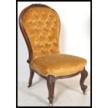 A Victorian 19th century mahogany spoon back nursing chair of rococo form raised on scrolled legs