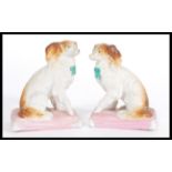 A pair of 19th century Continental Staffordshire type fireside dog figurines raised on pink