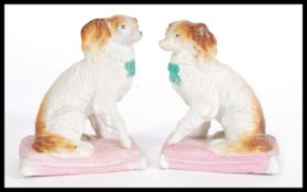 A pair of 19th century Continental Staffordshire type fireside dog figurines raised on pink