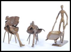 A collection of cold cast metal figurine ornaments depicting minimalist figures including a man