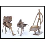 A collection of cold cast metal figurine ornaments depicting minimalist figures including a man