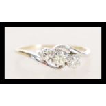 A stamped 14ct gold crossover ring prong set with three brilliant cut diamonds. Weight 2.7g. Size