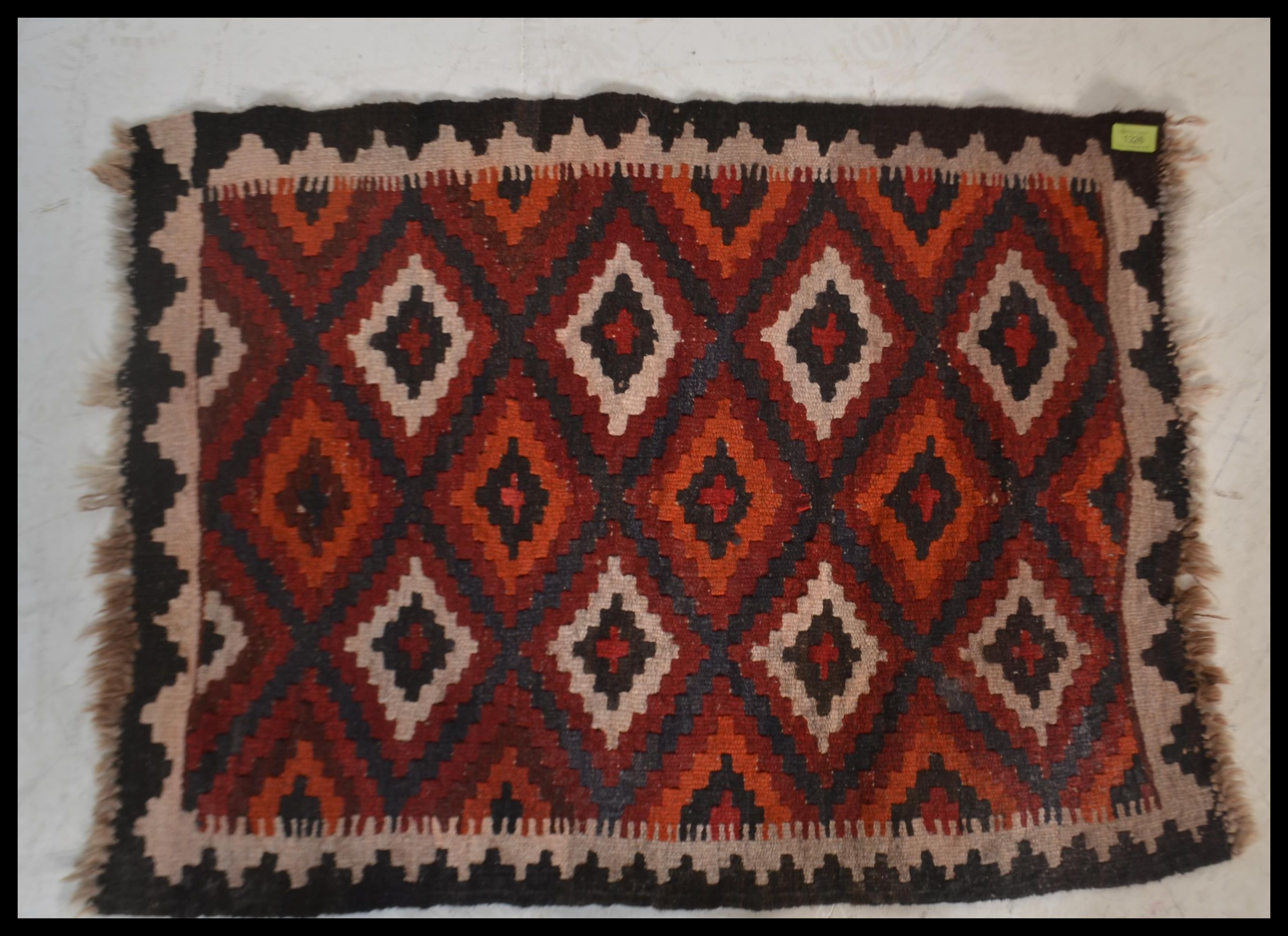 A 20th century  Islamic / Persian rug of small form with geometric patterns and triangular