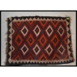 A 20th century  Islamic / Persian rug of small form with geometric patterns and triangular
