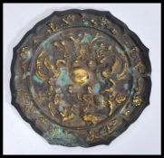 A Chinese 19th Century bronze mirror having embossed decoration of birds and florals to the back and