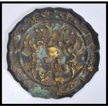 A Chinese 19th Century bronze mirror having embossed decoration of birds and florals to the back and