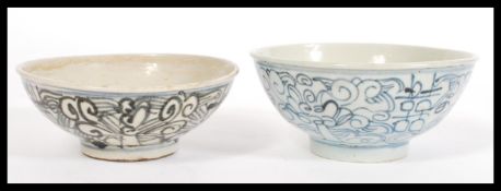Two late 18th early 19th century Chinese rice bowls having black hand painted scrolled decoration on