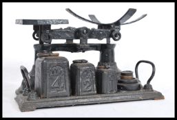 A vintage early 20th Century cast iron set of weighing scales complete with set of pillar weights.