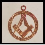 A hallmarked 9ct gold masonic pendant of circular form with central masonic symbol and engraved