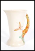 An early 20th century Clarice Cliff vase jug with crocus handle and butterfly decoration bearing