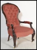 A Victorian 19th century mahogany armchair being raised on carved legs with ceramic castors having