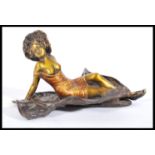 A 20th century cold painted bronze figurine sculpture of a semi dressed recumbent lady wrapped in