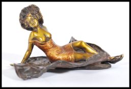A 20th century cold painted bronze figurine sculpture of a semi dressed recumbent lady wrapped in