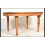 A vintage 20th century large teak wood dining table by Rainforest furniture raised on turned legs