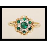 A hallmarked 9ct gold cluster ring set with green and white stones. Hallmarked Birmingham 1979.