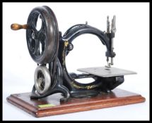 A rare 19th Century Victorian Wilcox & Gibbs sewing machine being set to a mahogany plinth, the