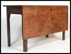 A 19th century George III mahogany large drop leaf dining table being raised on squared legs with