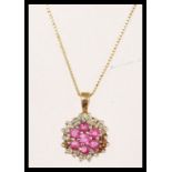 A hallmarked 9ct gold ruby and diamond cluster pendant necklace. Chain measures 18 inches, pendant