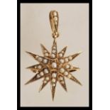 A stamped 9ct gold pendant in the form of a star with seed pearl decoration with bale hoop atop.