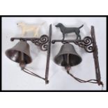 Two 20th century hand painted exterior cast iron metal wall hanging bells. Each with a hand