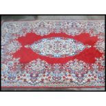 A Persian Islamic carpet rug on a red ground having one blue and cream floral medallion to the