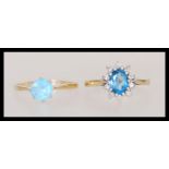 Two hallmarked 9ct gold rings one having a central faceted blue stone with a halo of white stones.