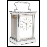 A 20th Century carriage clock in a silver white metal case having a white enamelled face to the
