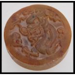 A Chinese Jade roundel seal of mottled brown colour carved with scrolling dragon motif and geometric