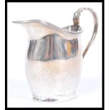 A hallmarked silver early 20th century creamer jug having a shaped acanthus leaf and reeded handle