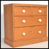 A Victorian pine country chest of drawers having 2 short over 2 deep drawers with white porcelain