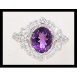 A sterling silver CZ and amethyst ring having a central faceted purple stone with a halo of white