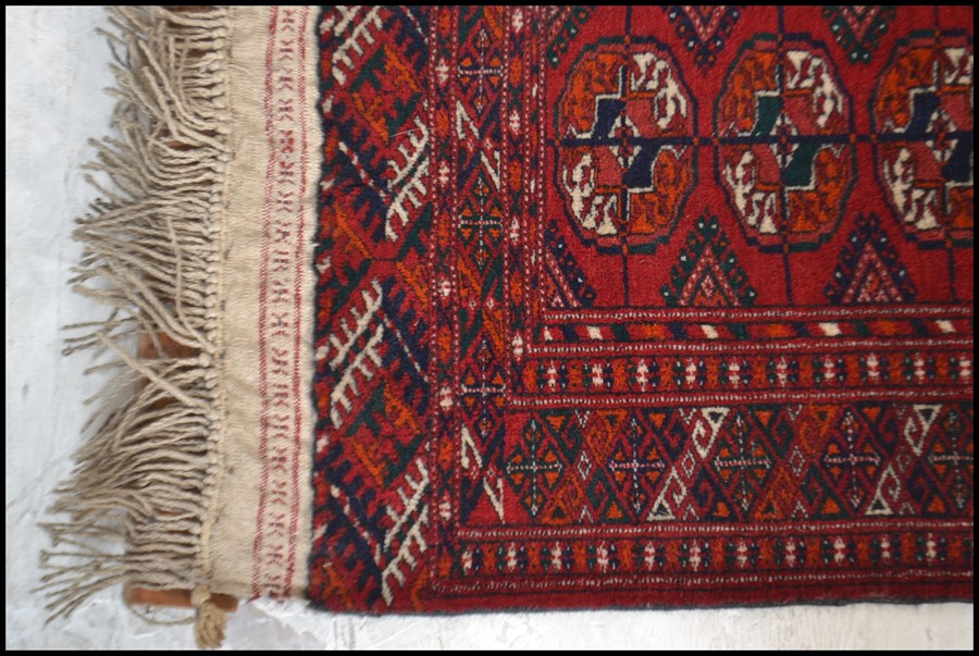 An early 20th century Islamic - Persian Bokhara rug with burnt orange ground having geometric - Image 3 of 4